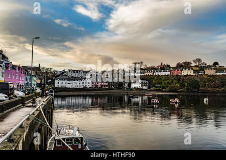 Portree Harbour, Isola di Skye in Scozia. Marzo 2017, mostrando la fila di case colorate, insieme contro una drammatica cloudscape. Foto Stock