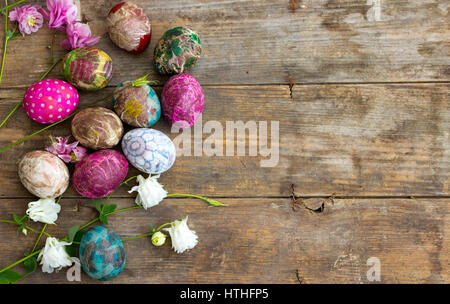 Gruppo di colorate uova di Pasqua decorate con fiori su sfondo di legno Foto Stock