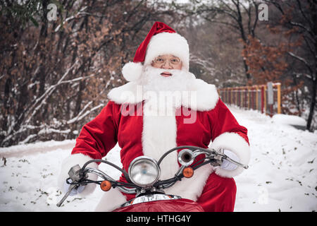 Babbo Natale a cavallo su scooter Foto Stock