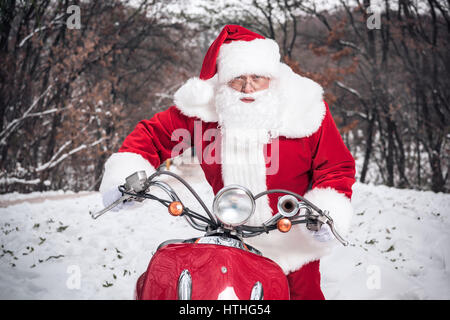 Babbo Natale a cavallo su scooter Foto Stock