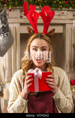 Sorpreso donna tenendo presente di natale Foto Stock