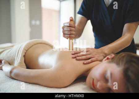 Massaggiatore con bastoni e aste al femminile di massaggio Foto Stock