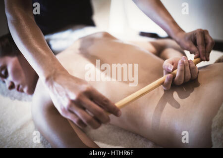 Massaggiatore con bastoni e aste al femminile di massaggio Foto Stock