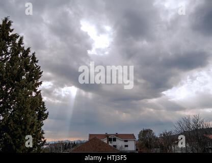 Sun fasci provenienti anche se nuvole temporalesche Foto Stock