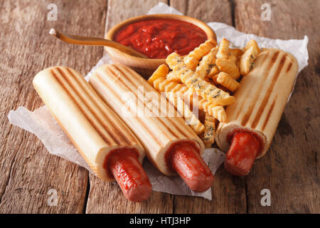 Grigliata di hot dog panini con patatine e salsa di pomodoro vicino sul tavolo orizzontale. Foto Stock