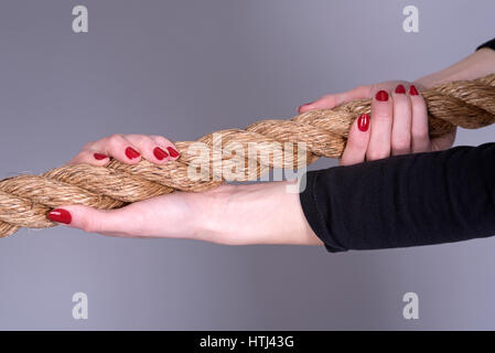 Donna con le mani le unghie verniciate di presa di una fune Foto Stock