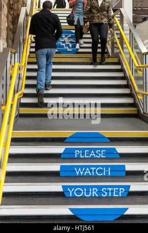 "Si prega di guardare il tuo passo' firmare su gradini. Norme di sicurezza per le persone a fare attenzione durante l'utilizzo di scale a Sheffield stazione ferroviaria, England, Regno Unito Foto Stock