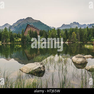 Il villaggio di Strbske Pleso lago di montagna in Alti Tatra, Slovacchia con rocce e erba in primo piano Foto Stock