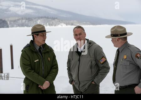 Stati Uniti Il Segretario degli Interni Ryan Zinke, centro, parla con park rangers durante una visita al Parco Nazionale di Glacier Marzo 10, 2017 in ghiacciaio Ovest, Montana. Foto Stock