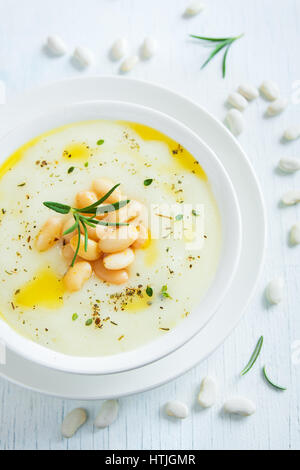 Bianco crema di fagioli e minestra di verdura con rosmarino in vaso bianco - in casa sana dieta vegana vegetariana zuppa cibo pasto Foto Stock