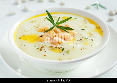 Bianco crema di fagioli e minestra di verdura con rosmarino in vaso bianco - in casa sana dieta vegana vegetariana zuppa cibo pasto Foto Stock