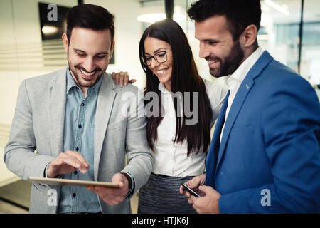 Happy business colleghi chat informali presso l'ufficio Foto Stock