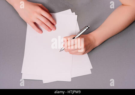 Le mani umane con la scrittura a matita su carta e cancellare la gomma sul tavolo di legno Foto Stock
