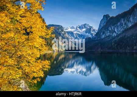 Bellissima vista idilliaca colorato paesaggio autunnale con Dachstein mountain summit riflettendo in crystal clear Gosausee lago di montagna nella caduta, Austria Foto Stock