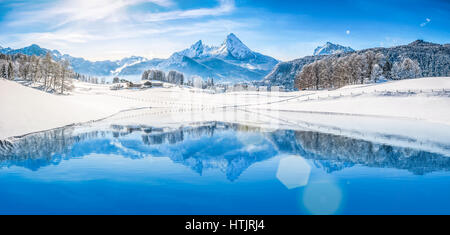 Vista panoramica della bella bianca winter wonderland scenario delle Alpi con la montagna innevata vertici riflettendo in crystal clear mountain lake Foto Stock