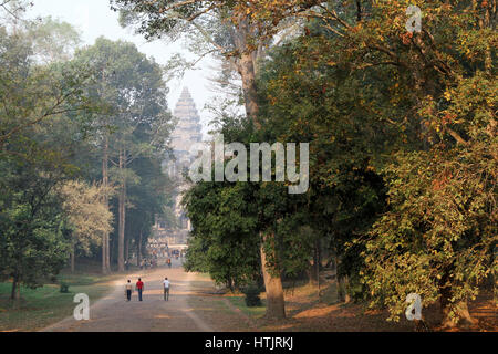 I turisti a piedi fino al percorso da porta orientale verso il tempio di Angkor Wat, al di fuori di Siem Reap, Cambogia. Foto Stock