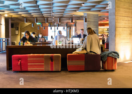 Persone che utilizzano Free Wifi pubblico presso il Teatro Nazionale su London Southbank, Waterloo. Foto Stock