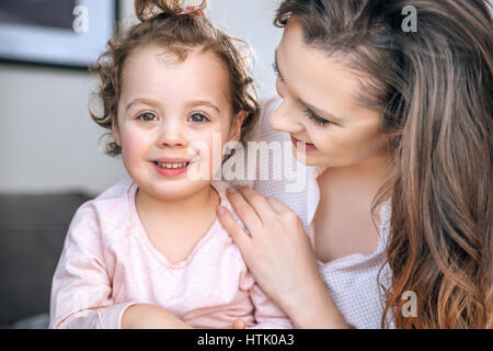 Attraente giovane madre abbracciando la sua diletta figlia Foto Stock