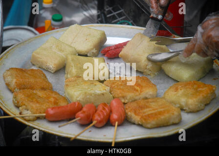 Donna cucinare il pesce al mercato, Hanoi, Vietnam. Foto Stock