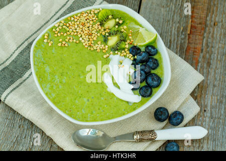 Frullato di verde da kale e banana con kiwi nella ciotola. Amore per un sano cibo vegan concept Foto Stock
