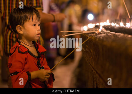 Shwedagon pagoda yangon, myanmar, XII marzo 2017. Un giovane pellegrino accende una candela in un santuario durante il tabuang luna piena festival. la luna piena è un momento importante per i pellegrini a visitare il Myanmar è più sacra buddista pagoda. tabuang la luna piena è il più promettente e si verifica ogni marzo. Credito: Trevor thompson/alamy live news Foto Stock