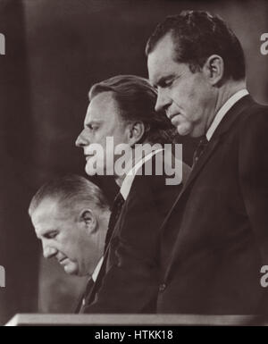 Billy Graham dando la benedizione di chiusura al 1968 Convention Nazionale Repubblicana affiancata da candidato presidenziale Richard Nixon (r) e vice candidato presidenziale T. Spiro Agnew (l) a Miami Beach, Florida, Stati Uniti d'America. Foto Stock