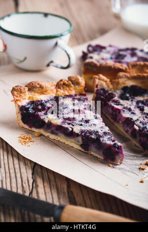 In casa la deliziosa torta di berry stratificata con crema pasticcera su tavola in legno rustico pronto a mangiare Foto Stock