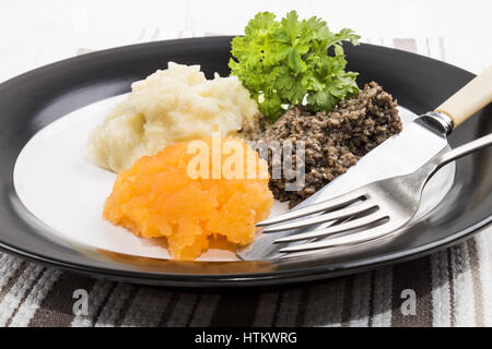 Tipico pasto scozzese sulla notte di Burns, haggis, svedese e purea di patate su una piastra Foto Stock