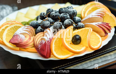 Bianco frutta splendidamente fette di arance e mele, pesche, kiwi e uva da vicino Foto Stock
