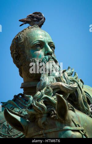 Pigeon seduti sulla testa del pilota su di una classica storica statua equestre in bronzo preening stessa contro un cielo blu Foto Stock