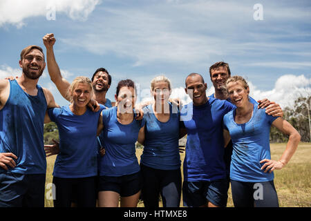 Gruppo di mettere le persone in posa insieme in boot camp in una giornata di sole Foto Stock