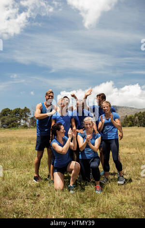 Gruppo di montare la gente acclamava insieme in boot camp sul giorno di sole Foto Stock