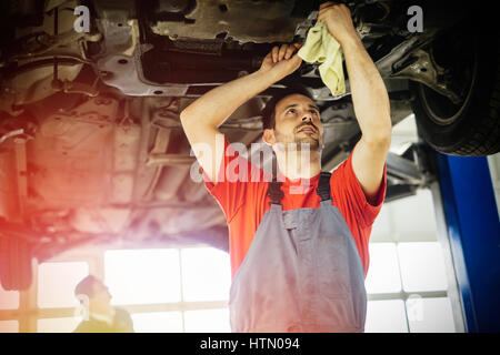 Meccanici a lavorare sulla vettura manutenzione Foto Stock