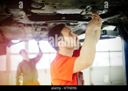 Meccanici a lavorare sulla vettura manutenzione Foto Stock