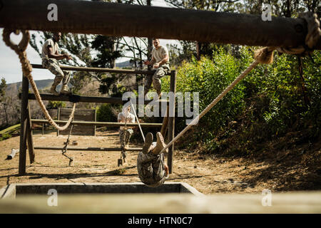 I giovani soldati militari la pratica di arrampicata corda durante la corsa a ostacoli a Bootcamp Foto Stock