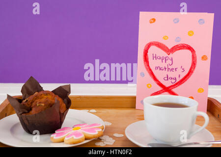 Felice Festa della mamma biglietto di auguri con tè e snack sul vassoio in legno Foto Stock