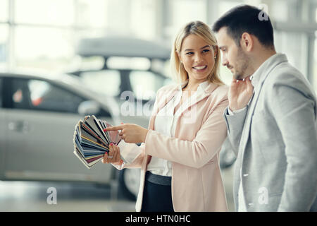 Il cliente scegliendo colore auto in concessionaria Foto Stock