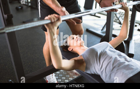 Personal trainer assiste la donna perdere peso in palestra Foto Stock