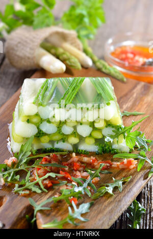 Gelatina di asparagi con carni bianche e verdi Asparagi e erba cipollina, servita con pepe rosso vinaigrette Foto Stock