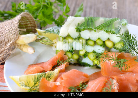 Gelatina di asparagi con carni bianche e verdi Asparagi e erba cipollina, servita con delizioso salmone affumicato Foto Stock