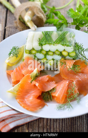 Gelatina di asparagi con carni bianche e verdi Asparagi e erba cipollina, servita con delizioso salmone affumicato Foto Stock