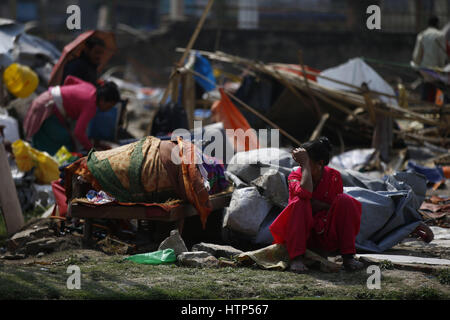 Kathmandu, Nepal. Xiv Mar, 2017. Una donna Nepalese si siede accanto a lei rimanenti beni dal suo rifugio di fortuna dopo che è stato abbattuto dalla polizia in un campo di spostamento per le vittime del terremoto a Chuchepati, Kathmandu, Nepal Martedì, Marzo 14, 2017. Più di centinaia di vittime vivevano in campo dopo aver perso le loro case nel 2015 terremoti. Credito: Skanda Gautam/ZUMA filo/Alamy Live News Foto Stock