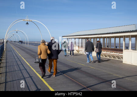 Southport, Merseyside, Regno Unito. Regno Unito Meteo. Il 14 marzo 2017. Luminosa e ariosa con un cielo azzurro per pier passeggini. Barmy marzo temperature continuare nel nord ovest, ma con un po' di più vento rispetto a quella di fine. Le persone sono ben confezionate fino contro la brezza del mare come essi passeggiata verso la fine del 2° molo più lungo in Inghilterra. Credito: MediaWorldImages/Alamy Live News Foto Stock