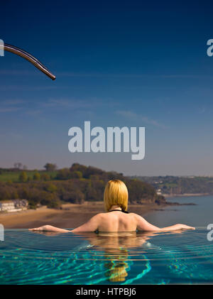 Giovane donna rilassante nella piscina infinity, St.Brides Spa Hotel, Saundersfoot, Pembrokeshire, Galles, Gran Bretagna Foto Stock