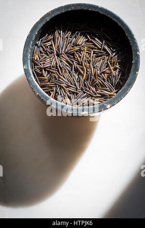 Riso selvatico in una ceramica ciotola nero su uno sfondo di marmo Foto Stock