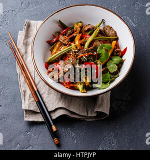 Carni bovine Szechuan stir fry con verdure nella ciotola in pietra scura sullo sfondo Foto Stock