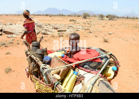 KENYA Marsabit, Samburu tribù pastorale, donna con bambini su donkey vagare con il loro bestiame alla ricerca di acqua e pascoli / KENIA, Marsabit, Samburu Familie mit Eseln und Ziegenherde auf Wanderschaft, Suche nach Wasser und Weideland fuer ihre Tiere Foto Stock