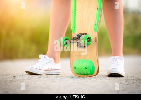 Anonimo ragazza adolescente con lo skateboard, immagine con la sunflare Foto Stock