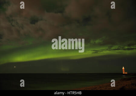 Aurora sopra il faro sulla Gardskagi, Keflavik, Islanda Foto Stock