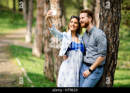 Giovane tenendo selfie nel parco della città Foto Stock